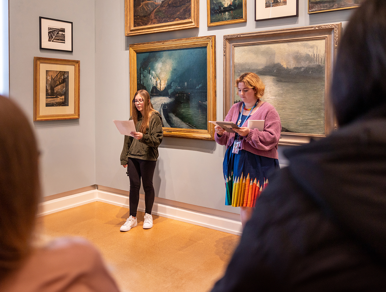 Photo from past ArtsWalk event showing two individuals in front of two different artworks